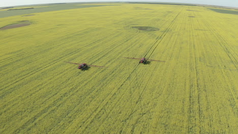 tractores rociando fungicida en canola en campo verde en el campo de canadá