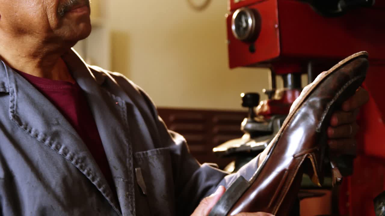 신발 제작자 가 신발 을 검사 하고 있다