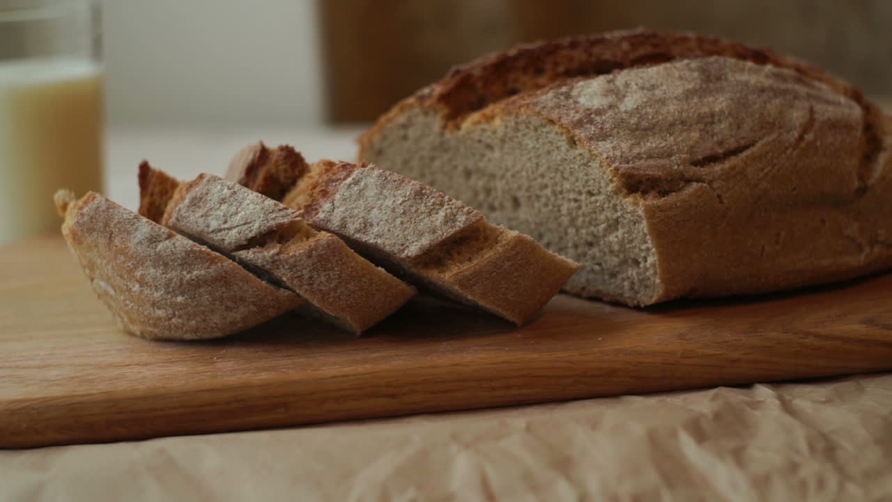Pieces of bread on cutting board at kitchen. Closeup of wheat bread slices
