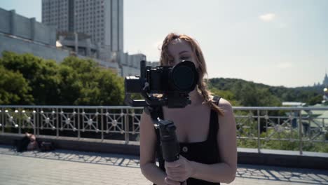 woman filming video on a rooftop with a drone camera