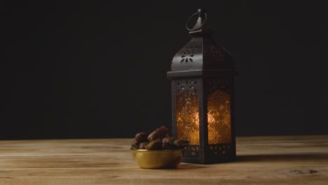 tracking shot of hand taking glass of water and date on a table for ramadan