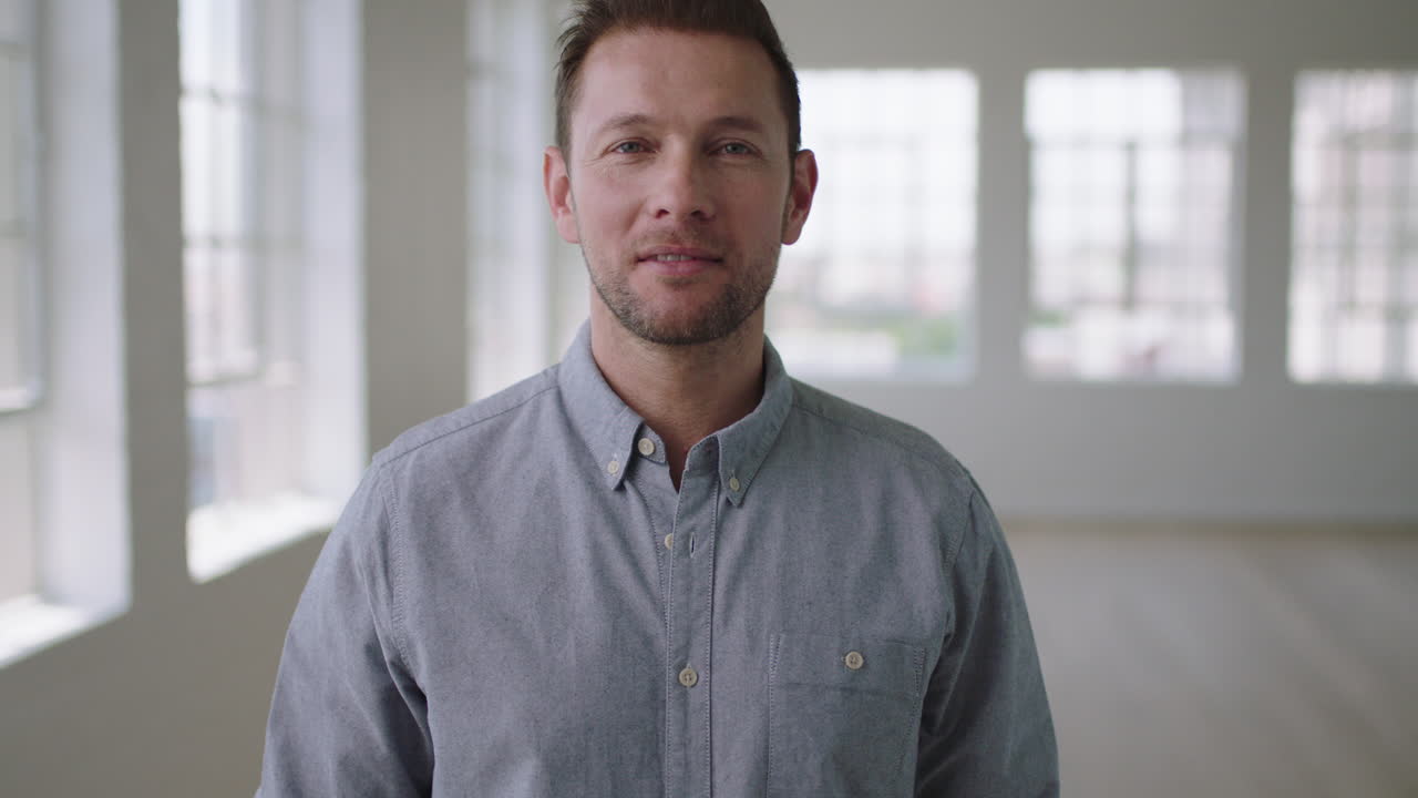 portrait of young caucasian man in empty apartment room looking confident at camera startup business idea