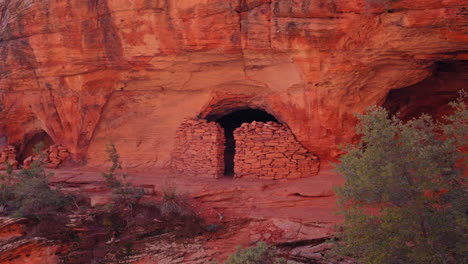 Alte-Ruinen-Einer-Schutzhütte-Aus-Rotem-Fels,-Eingebettet-In-Eine-Klippe