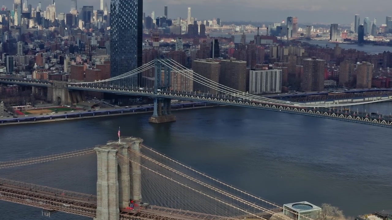 Vista del Ponte di Brooklyn con lo skyline della città sullo sfondo, sul fiume.