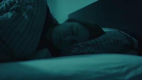 close up of woman turning in bed and falling asleep