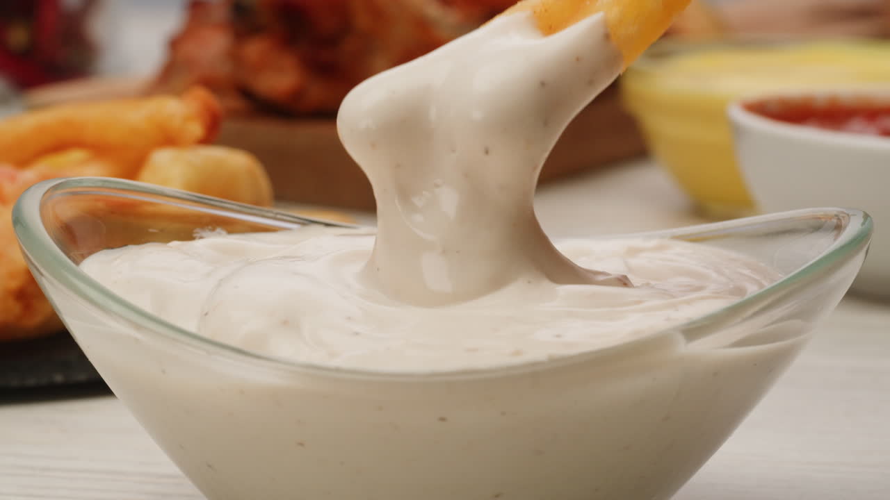 Dipping French Fries in Creamy Sauce