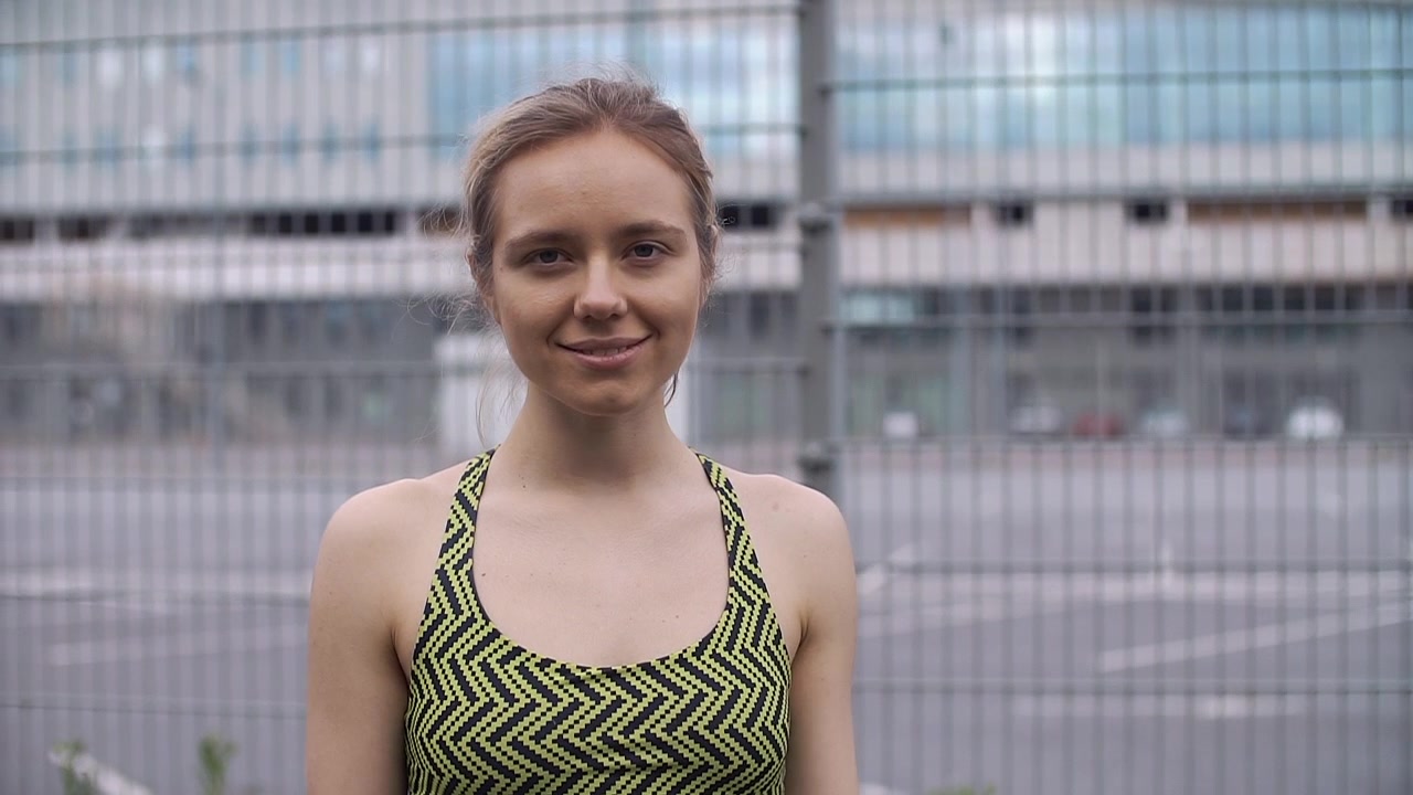 Giovane Donna che Controlla il Fitness Tracker e Sorride alla Fotocamera