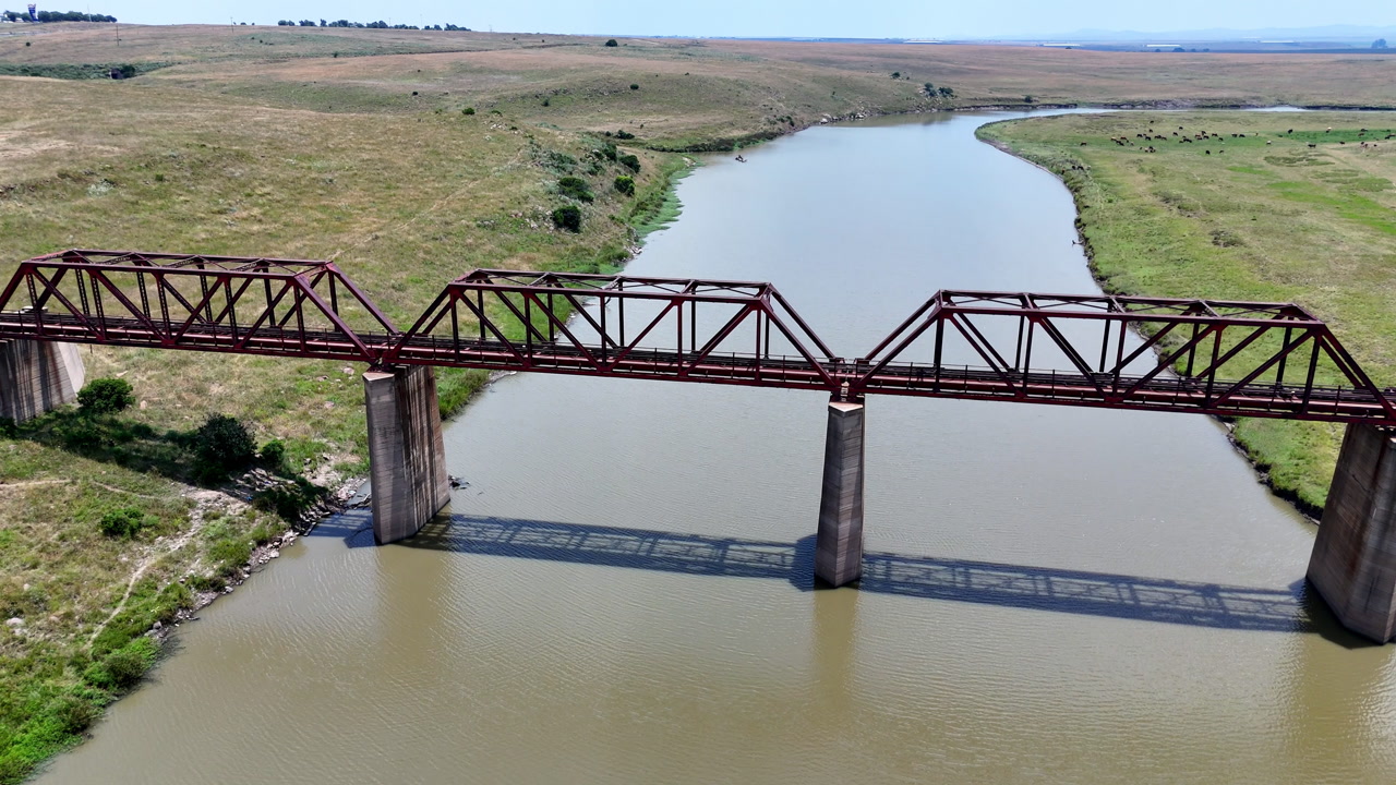 Drone flyover of an abandoned steel railway bridge over a river