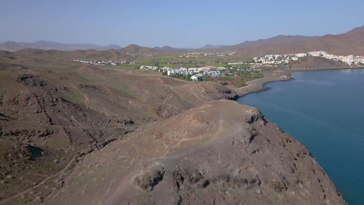 fuerteventura naturaleza. playitas resort emergiendo detrás de la montaña