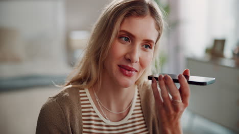 a woman smiling at her phone, applying lipstick