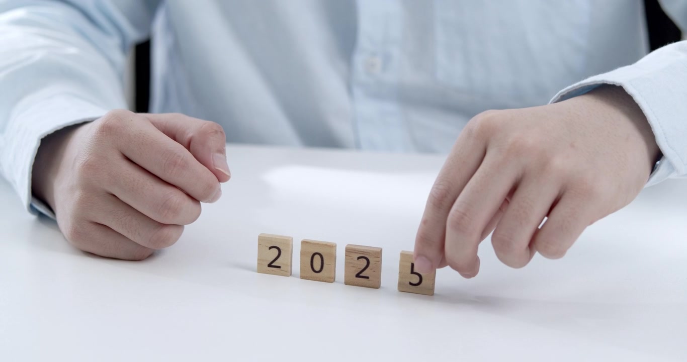 Jovem funcionário de escritório substituindo o número 4 pelo 5 para representar a transição de 2024 para 2025, destacando o conceito de planejamento, definição de metas e sucesso nos negócios.