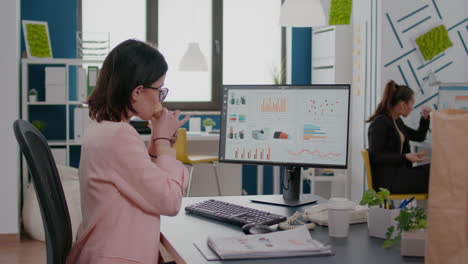 executive manager eating tasty sandwich while analyzing marketing strategy at desk