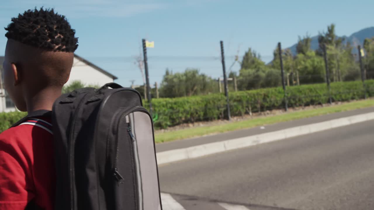Boy with school bag crossing the road