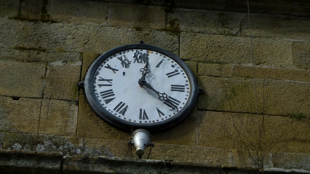 Vecchio quadrante di orologio arrugginito sulla facciata in mattoni di una sacra cappella a Santa Maria de Punxin, Ourense, Galizia, Spagna