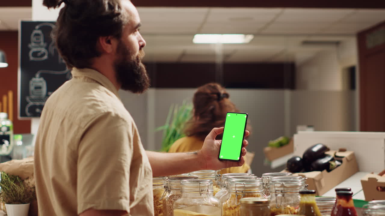 hombre usa teléfono de pantalla verde en la tienda de alimentos