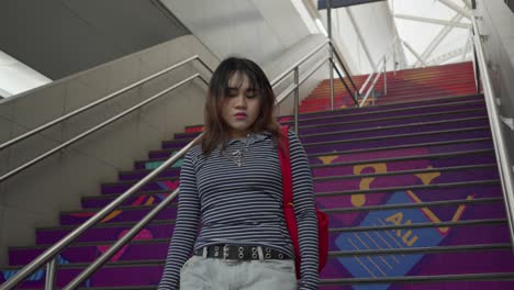 young woman walking upstairs indoors