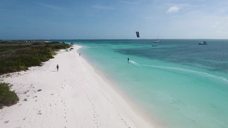 Vista-Aérea-Del-Hombre-Haciendo-Kitesurf-En-Una-Playa-Impresionante,-Mar-Caribe,-Los-Roques