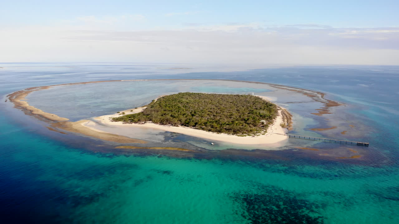 Aerial View of a Tropical Island Surrounded by Turquoise Ocean and Coral Reefs