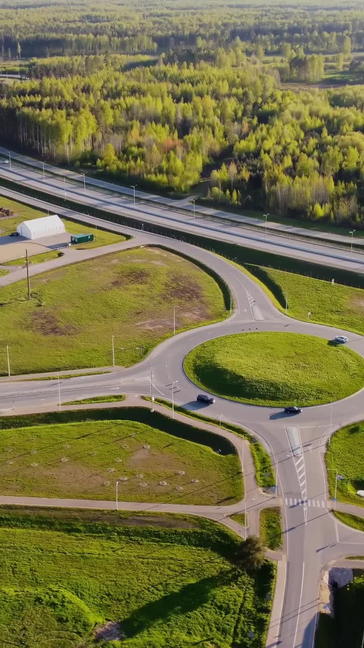 Drone shot of traffic on Katlakalns roundabout leading to highway through lush forests