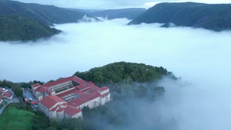 santo estevo monastery and foggy sil canyon from the air, luintra, spain