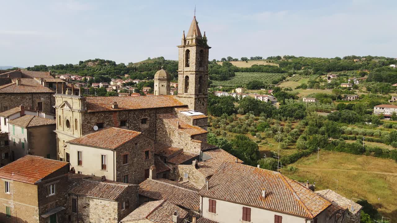 Stone village, Saint Nicolò bell tower surrounded by scenic Tuscan hills, fields