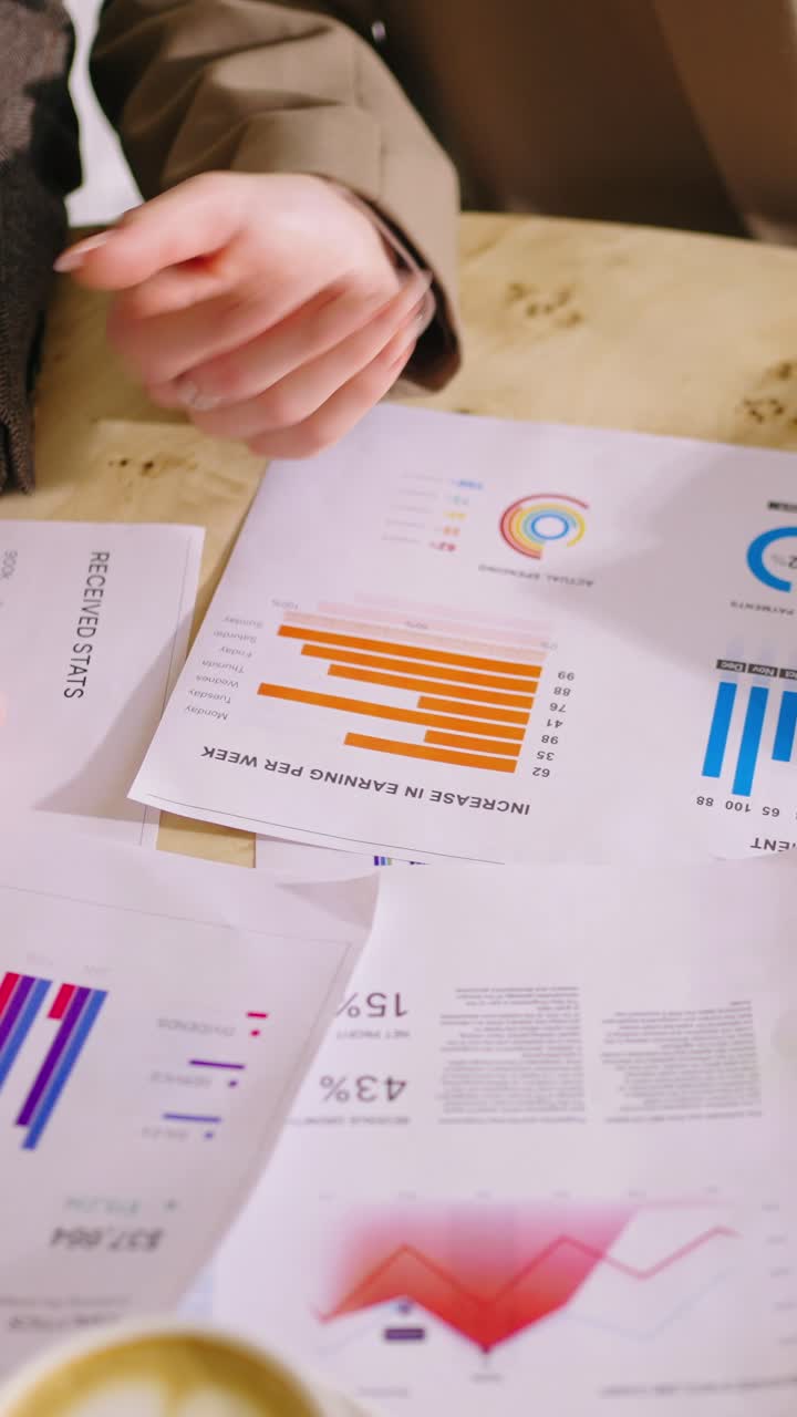 Close-up of Hands Analyzing Business Documents and Charts