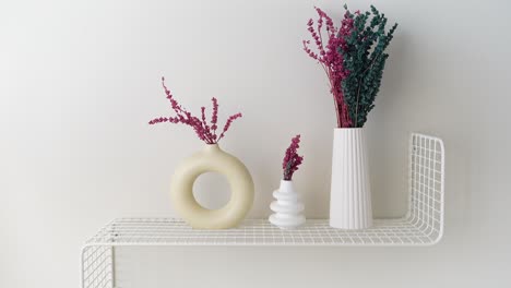 white shelf with dried flowers in vases