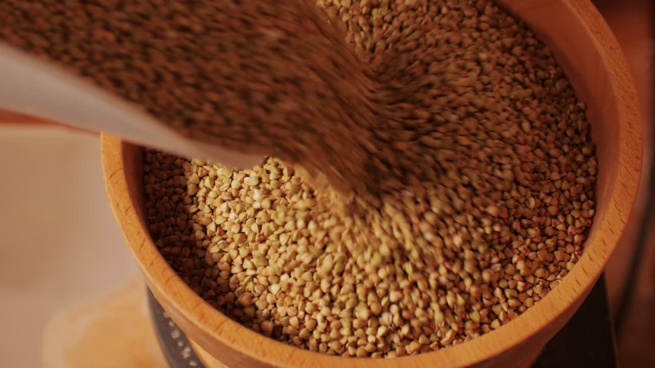 Close-up shot of treatment of seeds of cereals: rye, barley, wheat against diseases and insects using modern equipment. Hard wheat in hopper being ground into whole wheat flour. High quality 4k footage