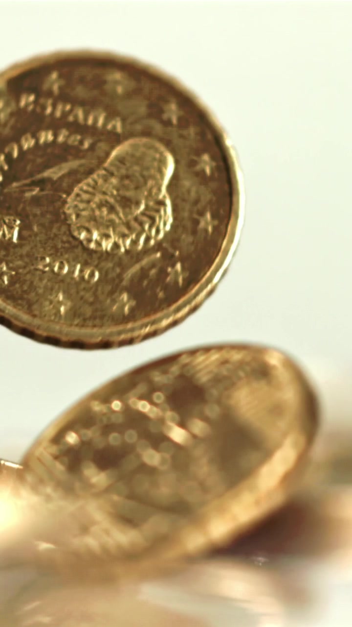 Primer plano de monedas de euro cayendo y amontonándose