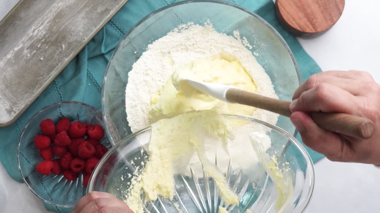 Making a dessert called Red Raspberry Tea Cake made with fresh berries and vanilla buttercream frosting. Great for Tea Parties. Adding red raspberries to the mixing bowl and combining the ingredients