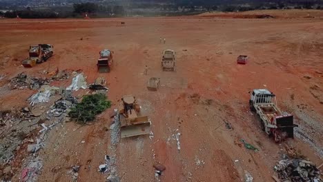 excavators and garbage trucks move piles of garbage at the brasilia dumping ground