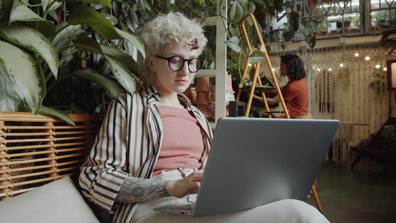 chica trabajando en una computadora portátil en una tienda de flores