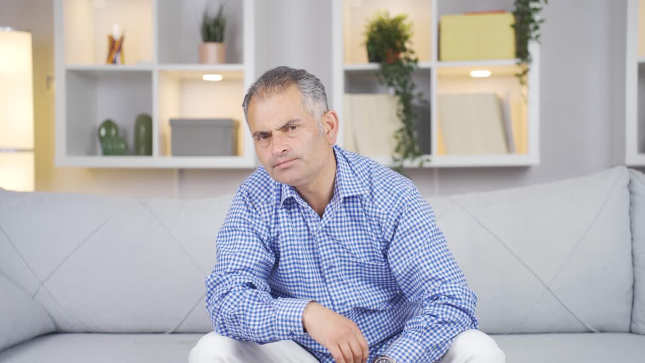 hombre mirando negativamente a la cámara.