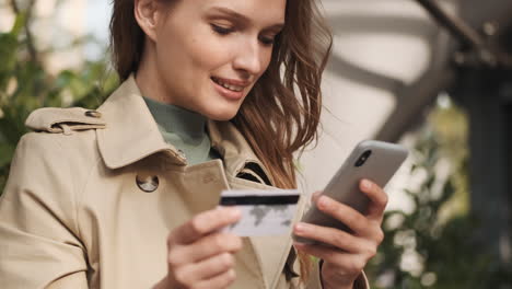 estudiante caucásica haciendo compras en línea en el teléfono inteligente al aire libre.