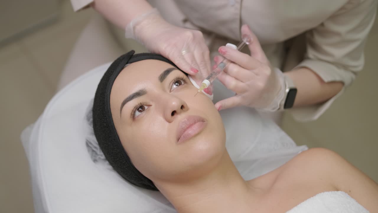 Woman making botulinum therapy in modern cosmetology clinic close up. Professional cosmetologist doing injection with botulinum toxin for rejuvenation face skin.