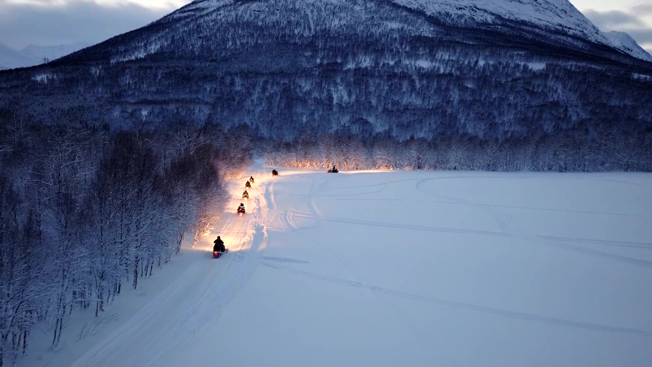 Ecoturismo in motoslitta nel paesaggio innevato di Tromsø, Norvegia, tracciamento aereo