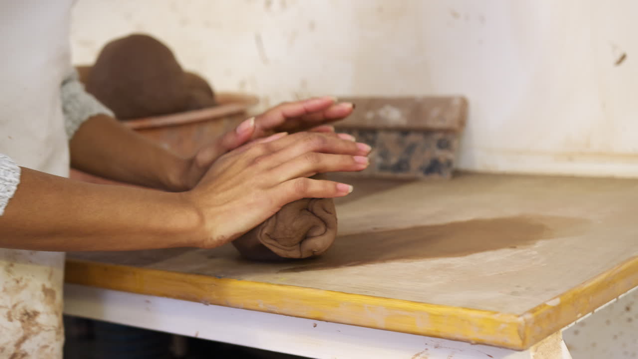 close up de mujer afroamericana alfarero rodando un pedazo de arcilla en el estudio de cerámica