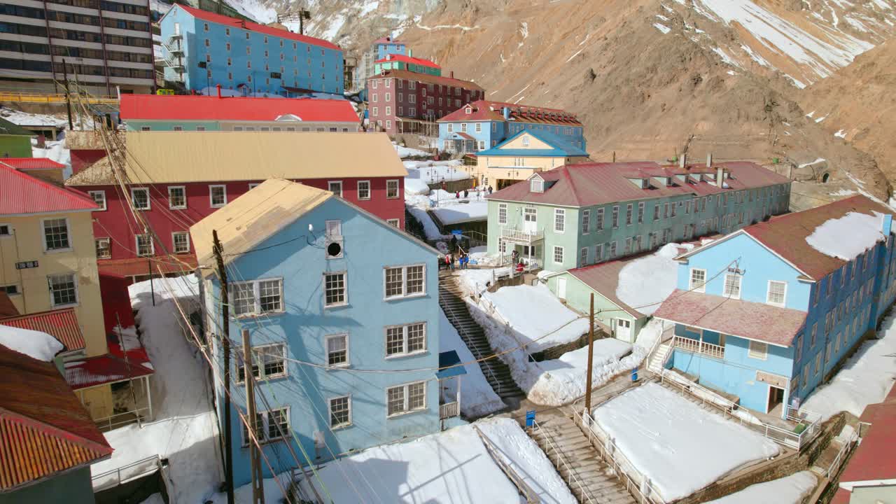 Aerial view of tourists in middle of vibrant buildings, sunny day in Sewell, Chile