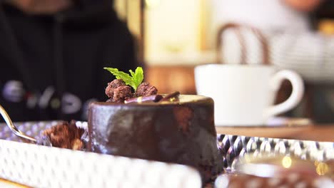 close up of person taking a piece of chocolate coulant dessert with spoon