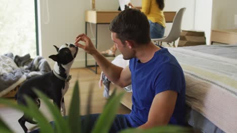 caucasian man is playing with his dog at home