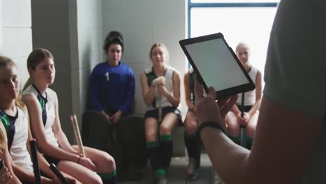 Hockey-coach-using-digital-tablet-in-locker-room