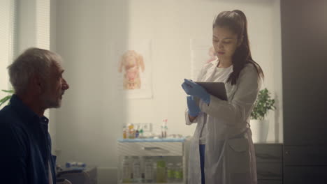 Physician woman testing patient using tablet in hospital closeup. Health concept