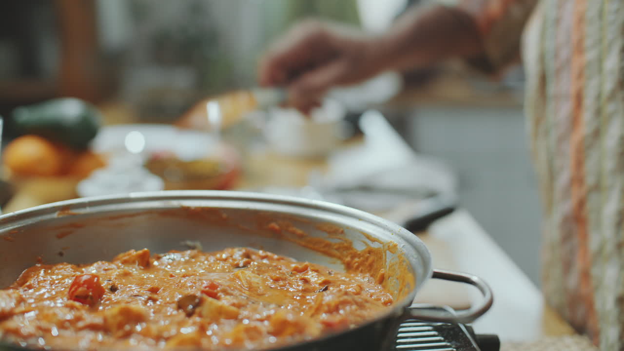 manos de hombre añadiendo jugo de limón y agitando mantequilla de paneer masala en la sartén