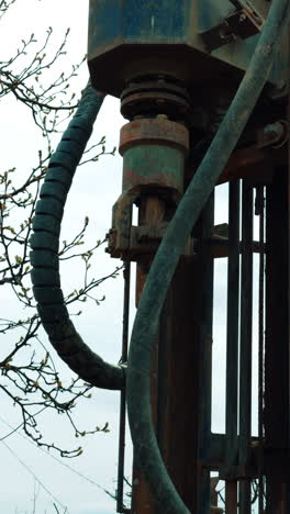 machine element spins the forcer for drilling the ground. machine boring the well outdoors. vertical video.
