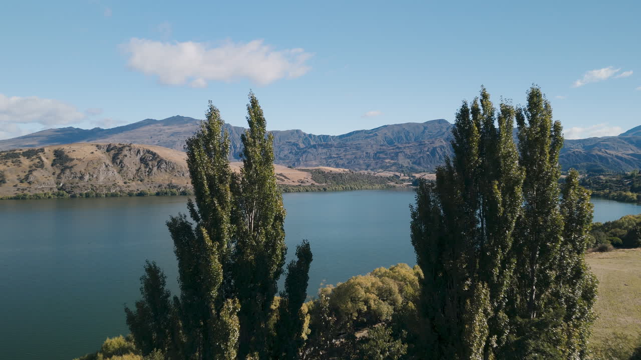 Aerial view of a lake surrounded by mountains and trees in New Zealand
