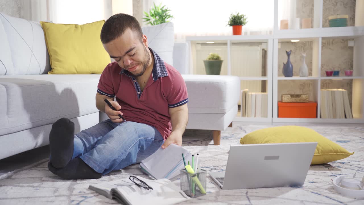 Young male student with dwarfism studying at home and enjoying himself.