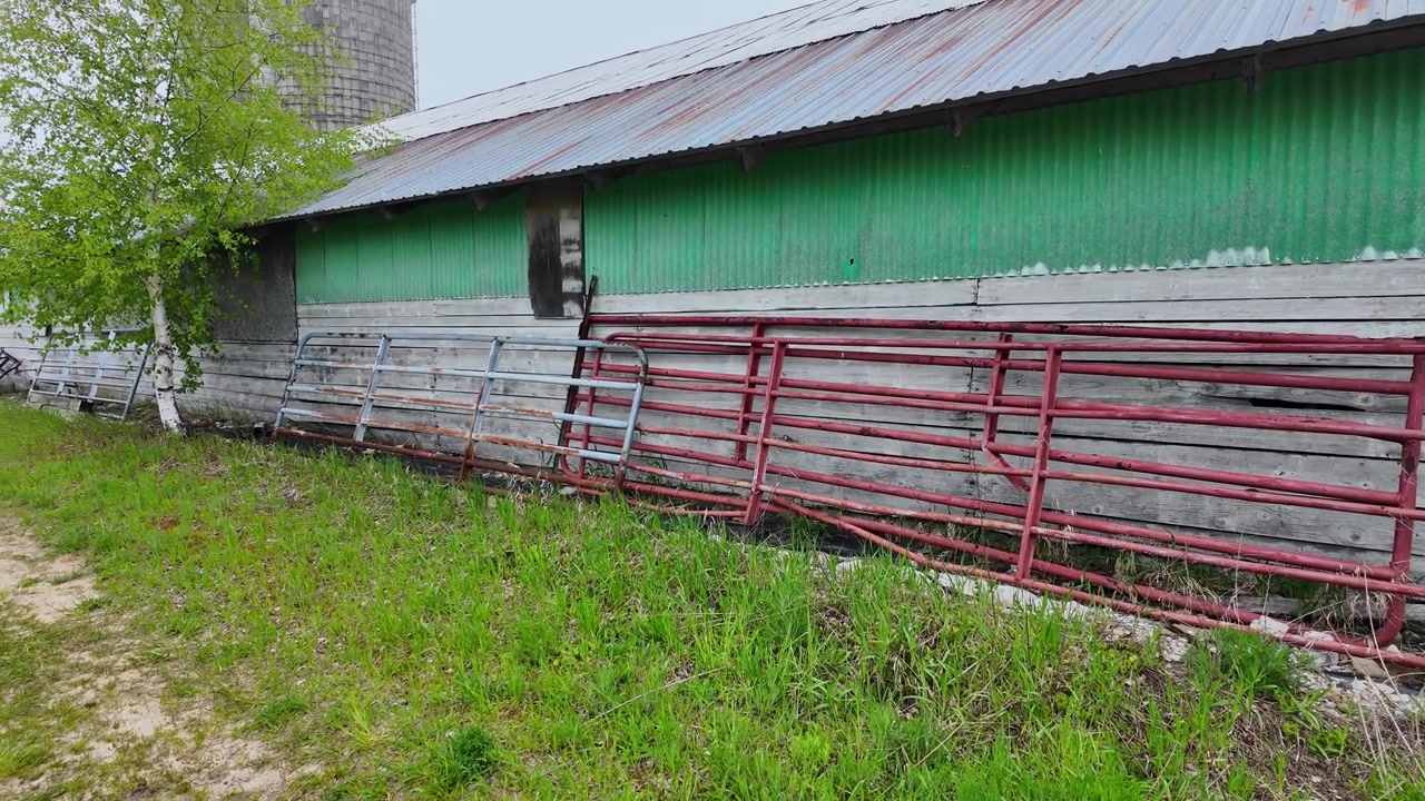 Tempo nebbioso mattutino che si muove su edifici agricoli rustici e un silo per il grano nel Michigan rurale