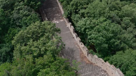 long and steep stairway of great wall of china in between green trees