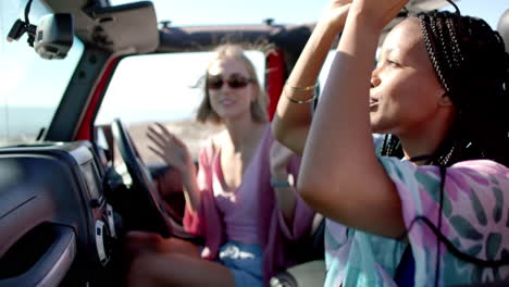 young african american woman and young caucasian woman enjoy a conversation in a car on a road trip