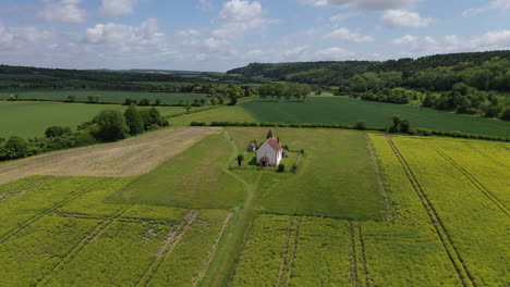 aerial orbiting small chapel in country fields summer uk